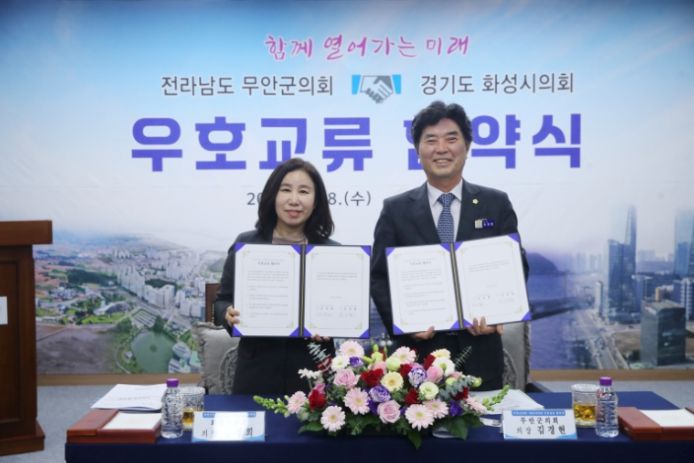 화성시의회(김경희 의장)와 무안군의회(김경현)가 우호교류 협약서 든 모습