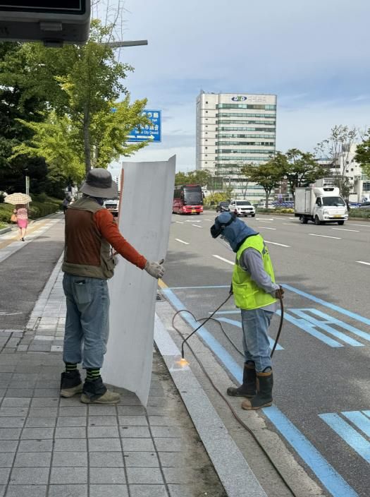 수원시청사거리~경기아트센터사거리 구간에 있는 화강암 경계석에 미끄럼 방지 시공을 하고 있다.