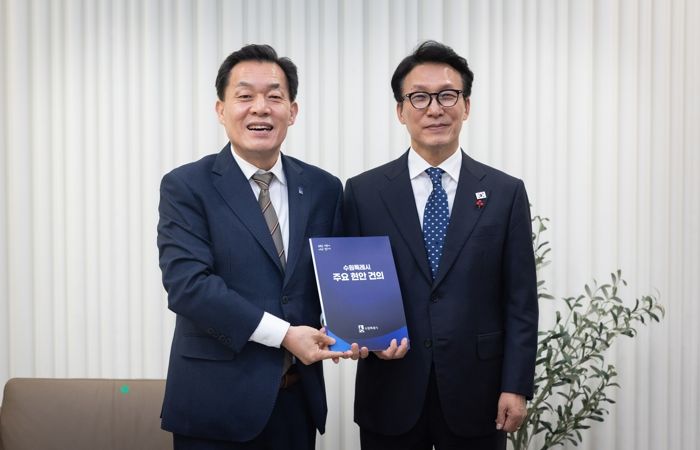 이재준 수원시장(왼쪽)이 김민석 국무총리에게 건의문을 전달한 후 기념촬영을 하고 있다.