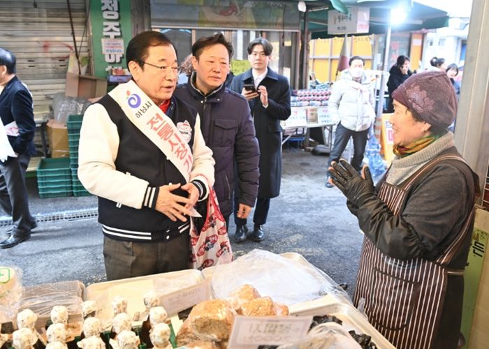 12일 오후 전통시장을 방문한 이현재 하남시장이 직접 장바구니를 들고 점포를 돌며 상인들에게 격려의 인사를 건네고 있다.